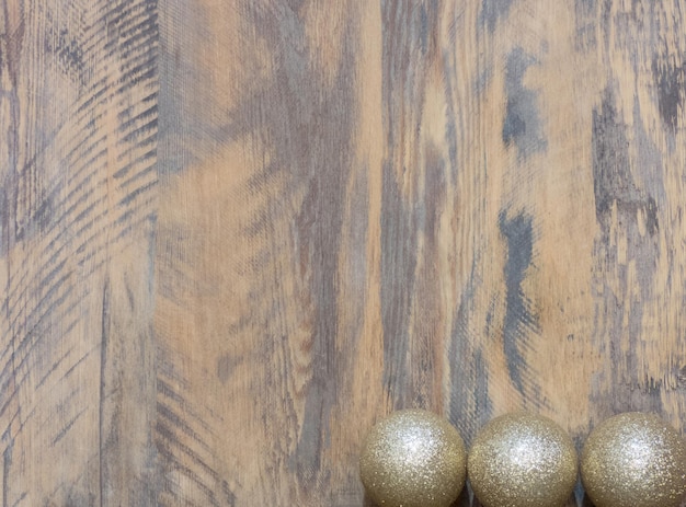 Glanzende en heldere gouden ballen op houten achtergrond. kerst versiering