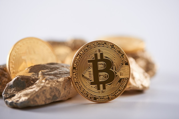 Glanzende gouden bitcoin naast brokken goud