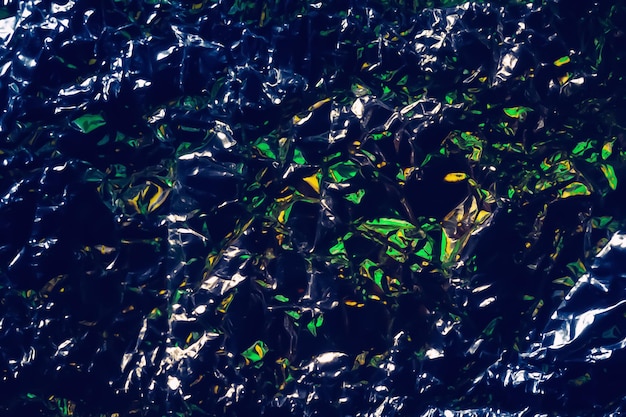 Glare surface Crumpled aluminum foil Crumpled background Colorful glitter on dark