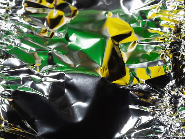 Glaring surface Crumpled aluminum foil Crumpled background Colored sparkle