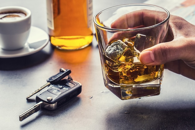 Glas alcohol hand man de sleutels van de auto en onverantwoordelijke bestuurder.