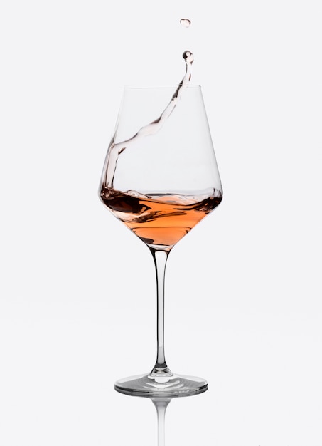 Glas amber wijn met spatten geïsoleerd op wit.