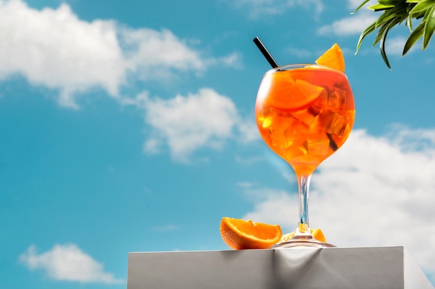 Glas aperol spritz cocktail en blauwe hemelachtergrond