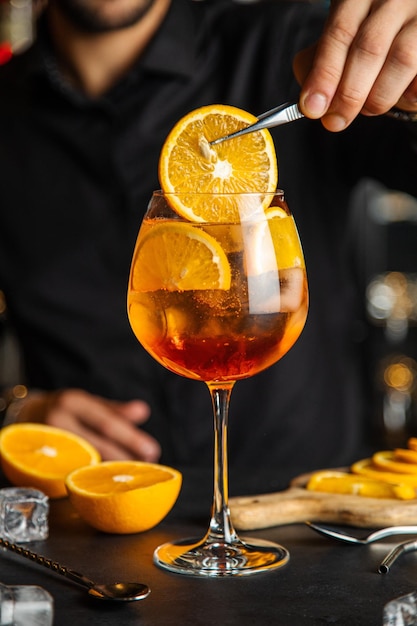 Glas aperol spritz cocktail met sinaasappelschil Spritz cocktail en op donkere achtergrond