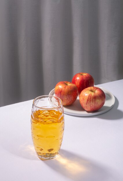 Glas appelsap met appels op de witte tafel