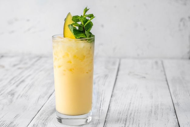 Glas Batida de Carneval gegarneerd met plakje mango en verse munt