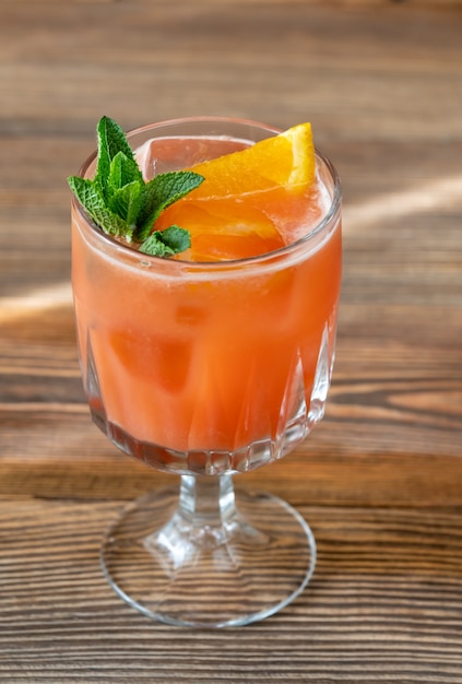 Glas Belmont Breeze Cocktail gegarneerd met schijfje sinaasappel en verse munt