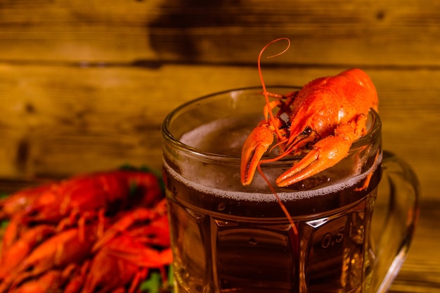 Glas bier en gekookte rivierkreeft op houten tafel