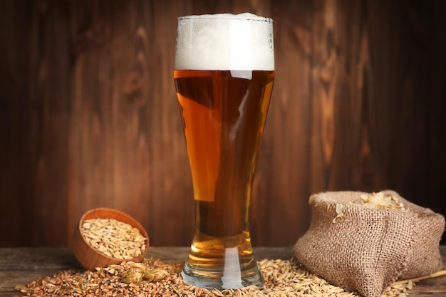 Glas bier en ingrediënten op houten ondergrond