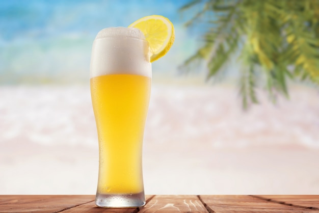 Glas bier met citroen op de achtergrond van de zee en de palmbomen
