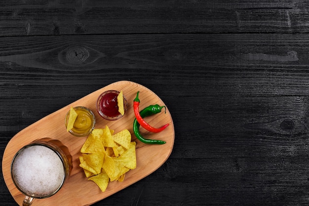 Glas bier met nachos chips op een houten ondergrond