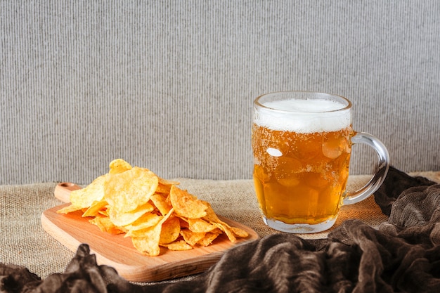 Glas bier, zoute chips op bruin