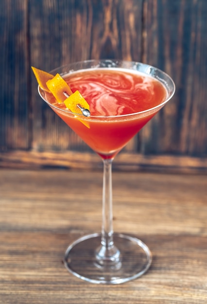 Glas bloed en zand cocktail in martini glas gegarneerd met sinaasappelschil