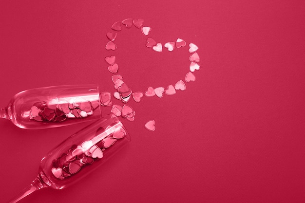 Glas champagne met rode hartjes op rode achtergrond Valentines achtergrond love date concept
