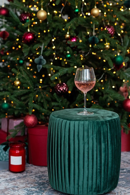 Glas champagne steeg tegen de achtergrond van bokehlichten van de kerstboom. Winter vakantie. Nieuwjaar achtergrond. Zachte selectieve focus.