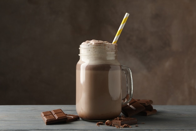 Glas chocolademilkshake op houten lijst.