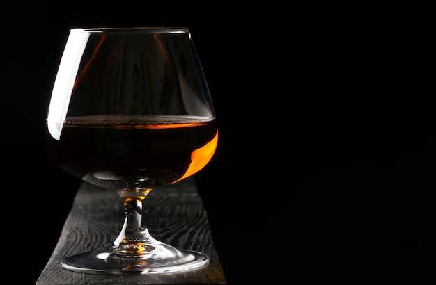 Glas cognac op de zwarte tafel