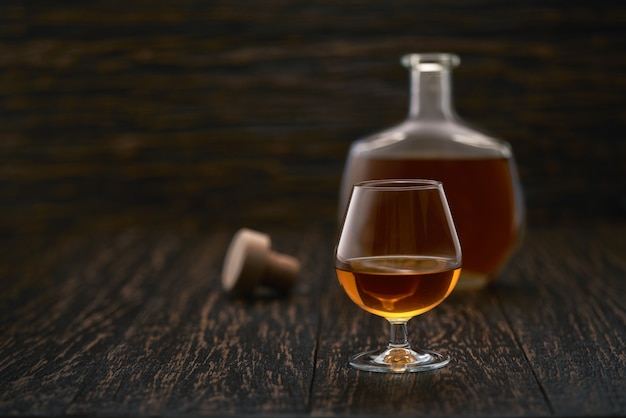 Glas cognac op een zwarte houten tafel.