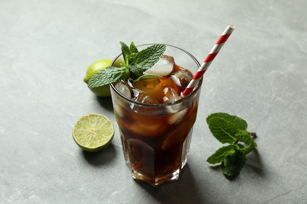 Glas Cuba Libre en ingrediënten op grijze ondergrond