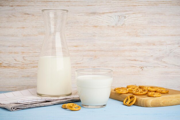 Foto glas en kruik verse melk op houten tafel tegen een achtergrond met kleur