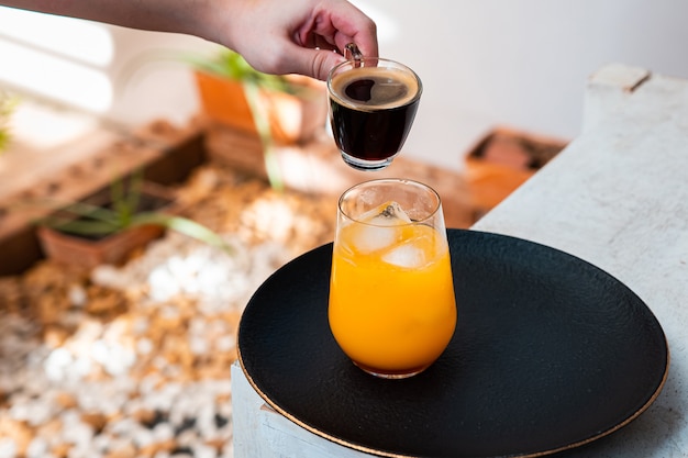 Glas espresso met jus d'orange op houten tafel en kopieer de ruimte.