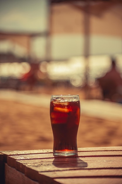 Glas frisdrank in het strandzand