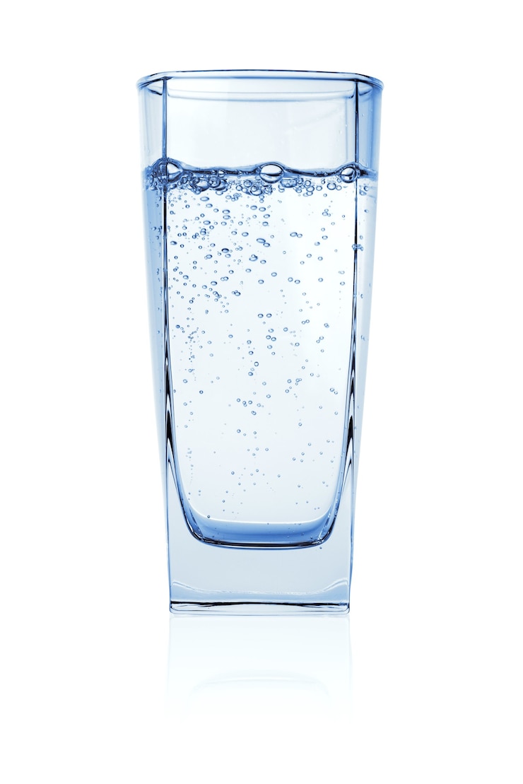 Foto glas frisdrank, koolzuurhoudend, bruisend water met gasbellen geïsoleerd op een wit oppervlak.