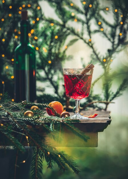 Glas glühwein met dennentakken en kerstverlichting