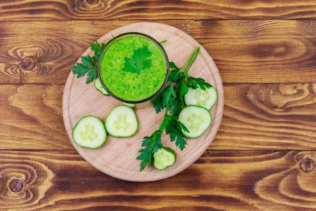 Glas groene detox-smoothie van komkommer en peterselie op een houten tafel Bovenaanzicht