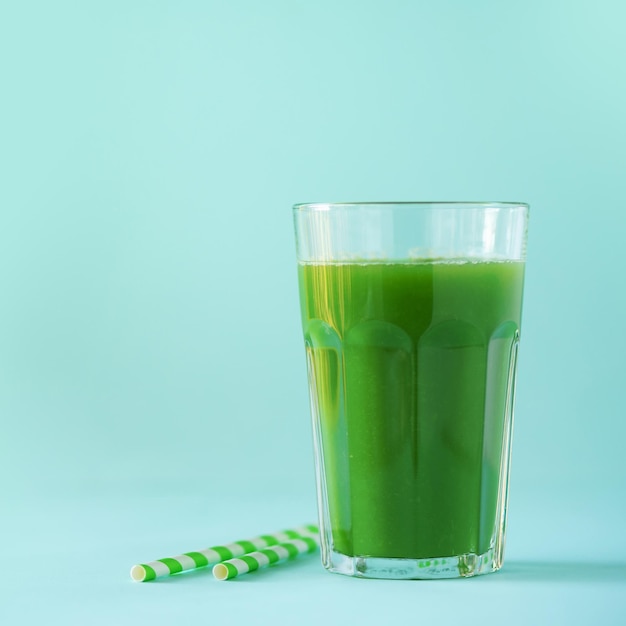Glas groene selderij smoothie op blauwe achtergrond Banner met kopie ruimte Vers sap voor detox Veganistisch alkalisch gezond dieet concept