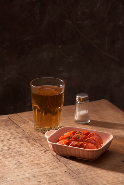 Glas heerlijk bier met gegrilde worstjes op houten tafel