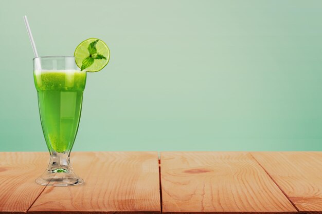 Glas heerlijke cocktail met schijfje limoen op houten tafel