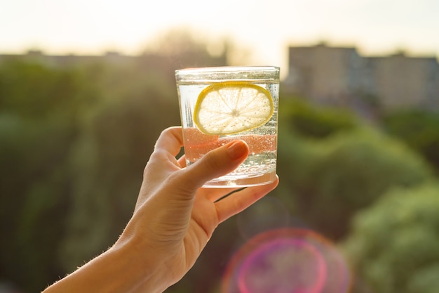 Glas helder, bruisend water met citroen in de hand