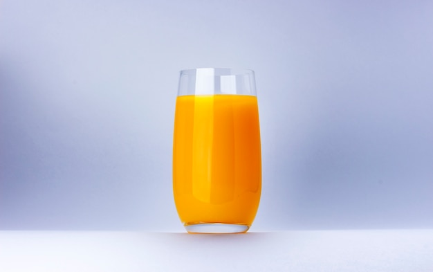 Glas jus d'orange dat op witte achtergrond met exemplaarruimte wordt geïsoleerd