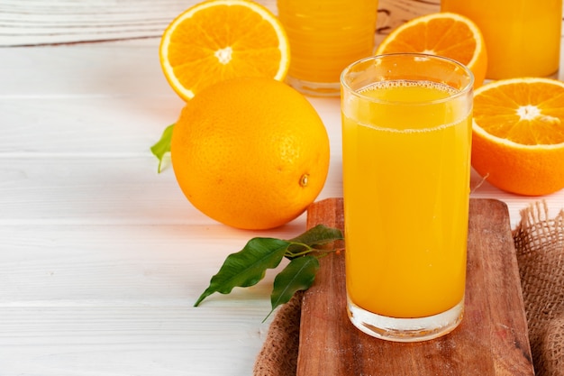 Glas jus d'orange en gesneden sinaasappelen op tafel