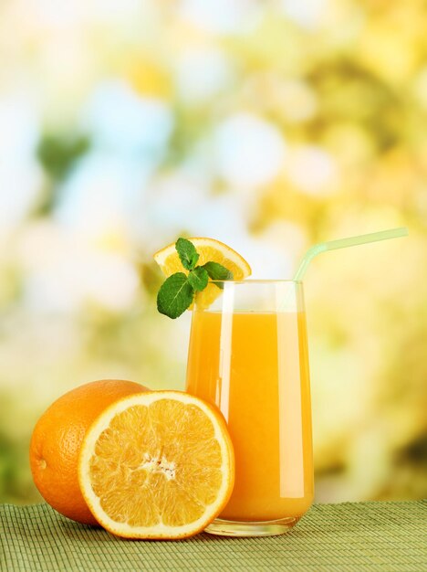 Glas jus d'orange met munt en sinaasappel op tafel op lichte achtergrond