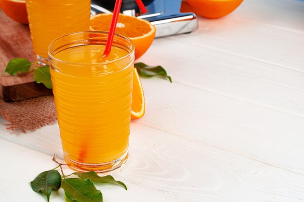 Glas jus d'orange met rood stro op tafel