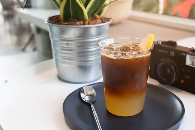 Glas koffie en camera op de tafel in het café