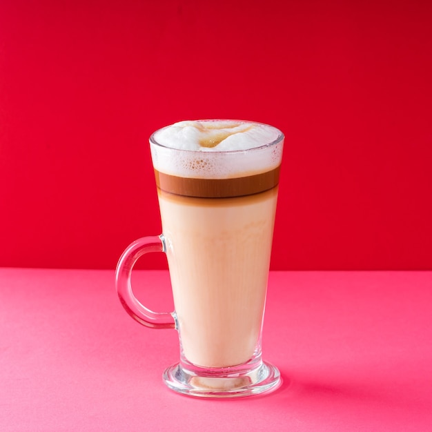 Glas koffie latte movha met melk en schuim op rode achtergrond