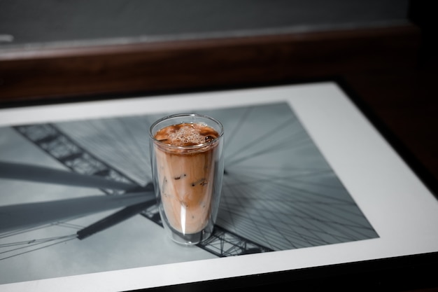 Glas koffie op tafel en grijze muur