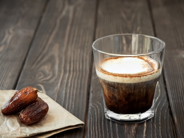 Glas kopje koffie met melk op een donkere houten oppervlak