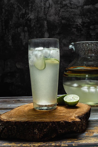 Glas koude limonade op houten tafel. Donkere achtergrond.