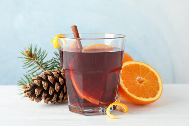 Glas lekkere glühwein met sinaasappel op witte houten tafel