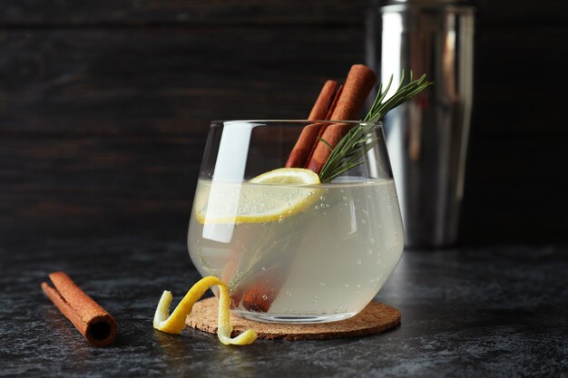 Glas limonade met kaneel en rozemarijn op zwarte smokey tafel