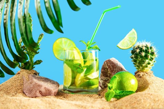 Glas limonade met limoen en munt tussen de zandduinen en cactussen