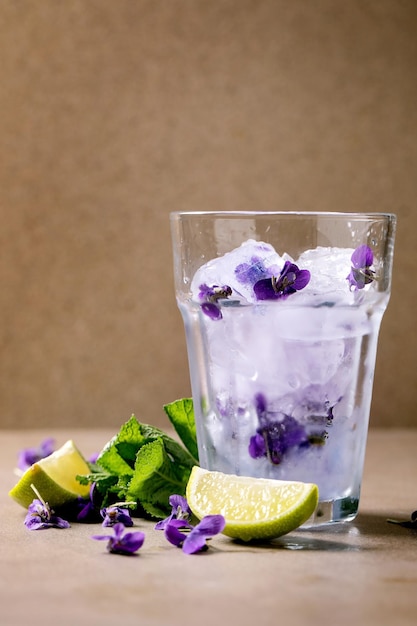 Glas limonadecocktail met viooltjesbloemen