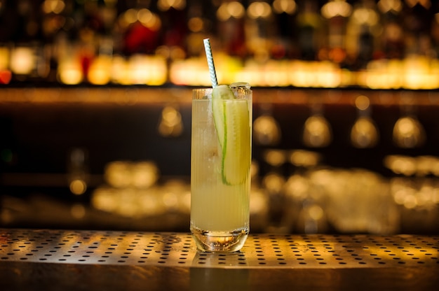 Foto glas lynchburg limonadecocktail met komkommer op de houten stalen toog