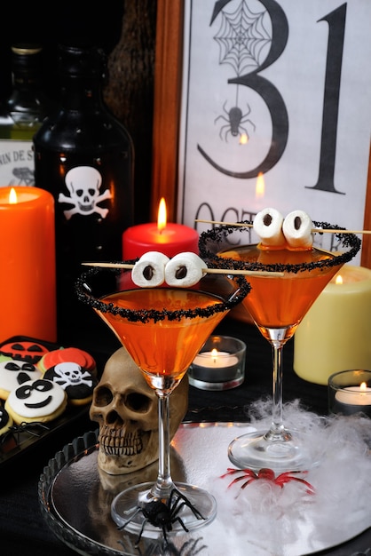 Glas martini versierd met zwarte suiker met marshmallow-ogen op tafel ter ere van Halloween