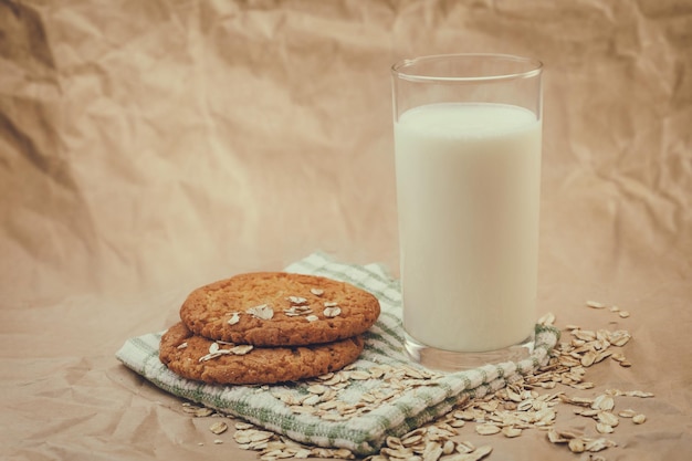 Glas melk en havermoutkoekjes op verfrommeld papier achtergrond