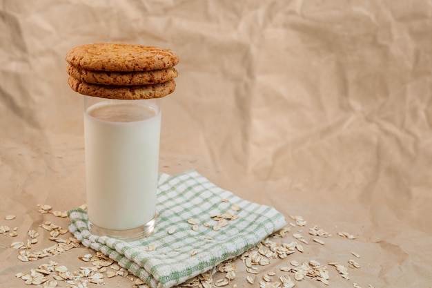 Glas melk en havermoutkoekjes op verfrommeld papier achtergrond